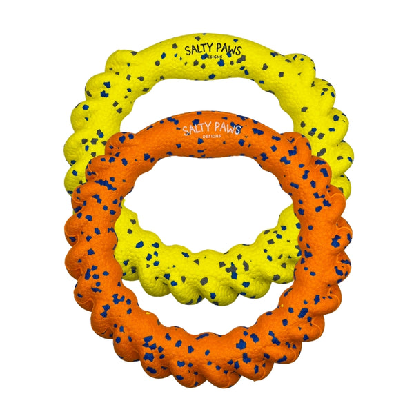 Two ETPU dog toy rings in bright yellow and orange, both speckled with small blue flecks. Both have the brand name 'SALTY PAWS' printed on it.