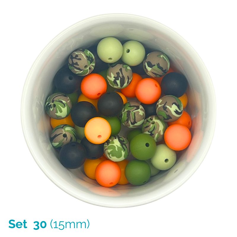 Set of camouflage-patterned beads in a white container on a white background