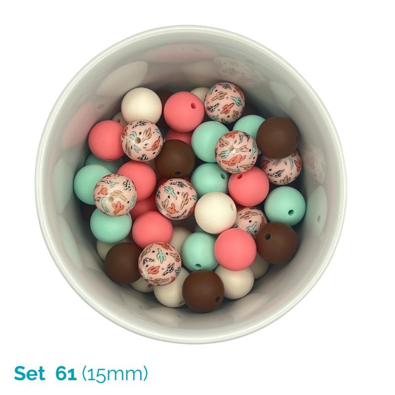 Assorted colorful beads in a white container on a white background