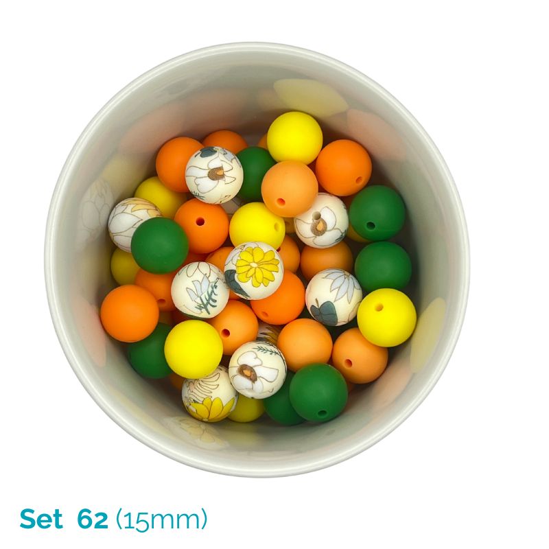 Assorted colorful beads with printed designs in a white container on a white background