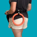 Salty Paws belt accessory clip attached to a belt holding a teal foam ring toy, hands-free dog training