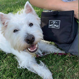 White Westie lying on grass next to Salty Paws Original Dog Training Treat Pouch