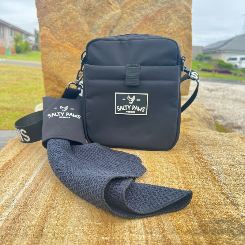Salty Paws Original Dog Training Treat Pouch with Slobber Towel laid out on sandstone surface, outdoor lifestyle