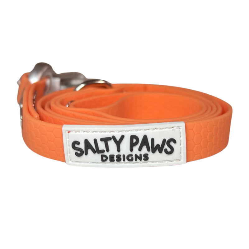 Salty Paws quick release waterproof dog lead in peachy orange, coiled showing frog clip hardware detail