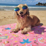 Golden retriever wearing sunglasses lying on Salty Paws Summer Days Adventure Dog beach Towel in pink