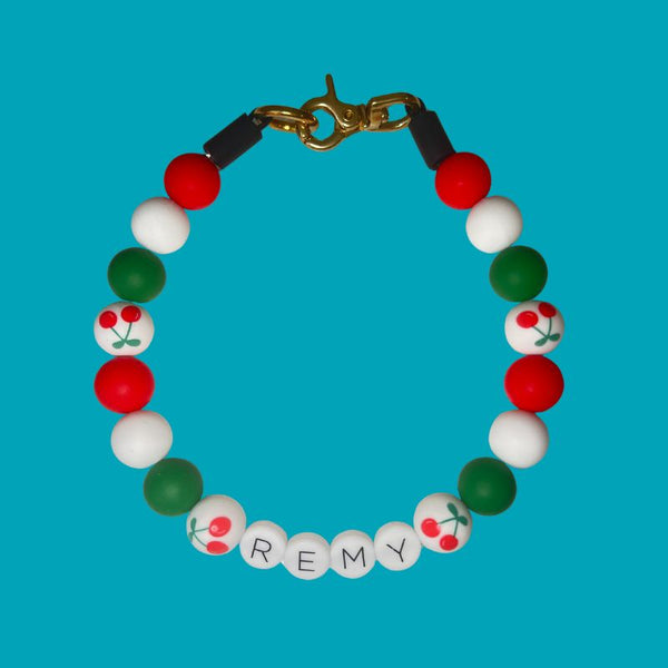 Colorful beaded bracelet with 'REMY' on a blue background