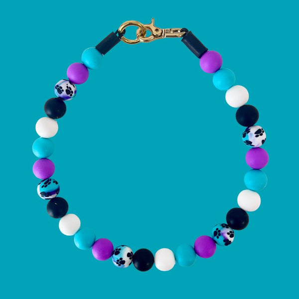 Colorful beaded bracelet with a gold clasp on a blue background