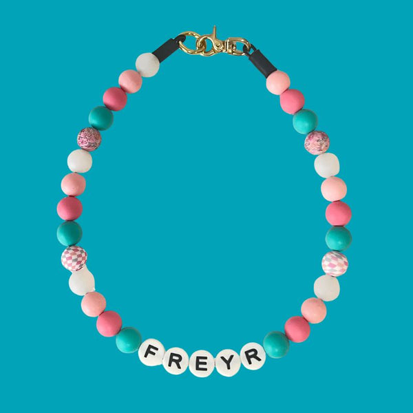 Colorful beaded necklace with 'FREYR' on a turquoise background