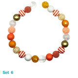 Colorful beaded dog necklace with various shapes and sizes on a white background