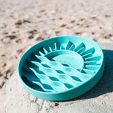 Salty Paws Sunset Slow Feeder in green on sandy surface showing sun and beach wave pattern