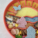 Close up of Sunset Slow Feeder in orange with wet food and enrichment treats in wave sections
