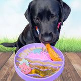 Black labrador eating from Sunset Slow Feeder in purple loaded with enrichment food